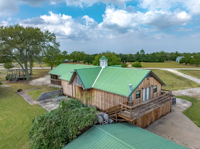 an aerial view of a house with swimming pool and green space