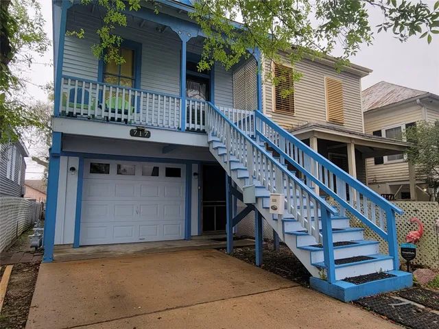a front view of a house with wooden stairs and a large window