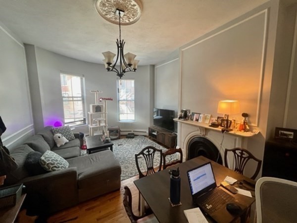 93 East Brookline Street, Unit 2 Boston, MA 02118 - Photo 8 of 8 a living room with furniture a chandelier and a window