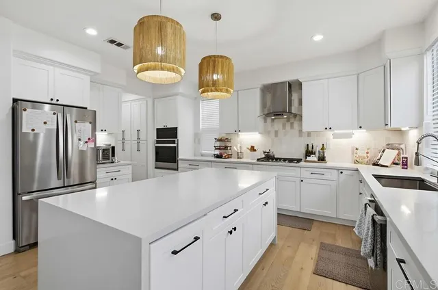 a kitchen with stainless steel appliances granite countertop a sink a stove and refrigerator