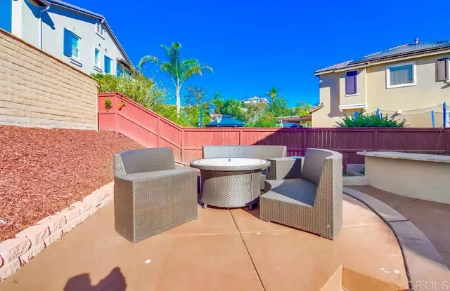 a view of a patio with couches table and chairs and potted plants