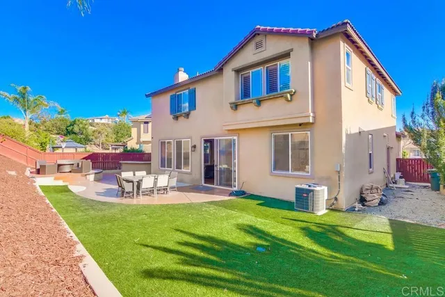 a view of a house with backyard sitting area and garden