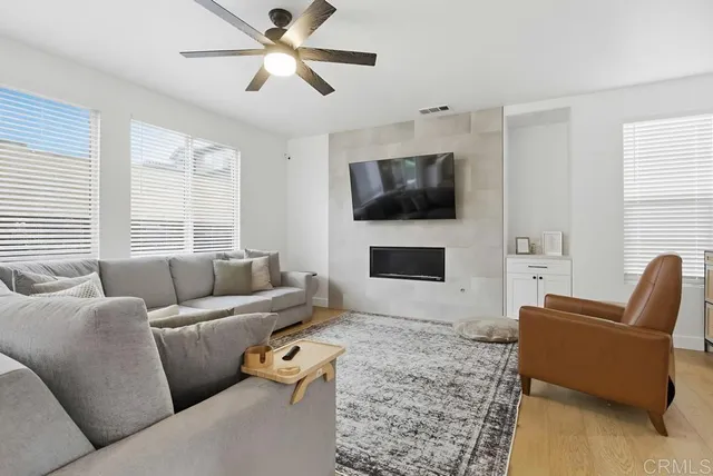a living room with furniture a flat screen tv and a window