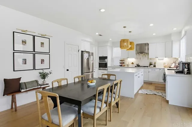 a dining room with stainless steel appliances kitchen island granite countertop a dining table and chairs