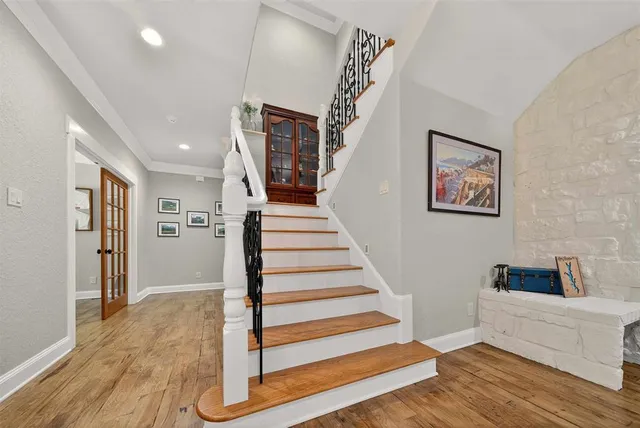 a view of a hallway with wooden floor and stairs