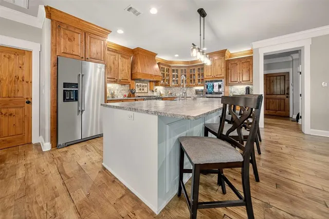a kitchen with granite countertop wooden cabinets and dining table