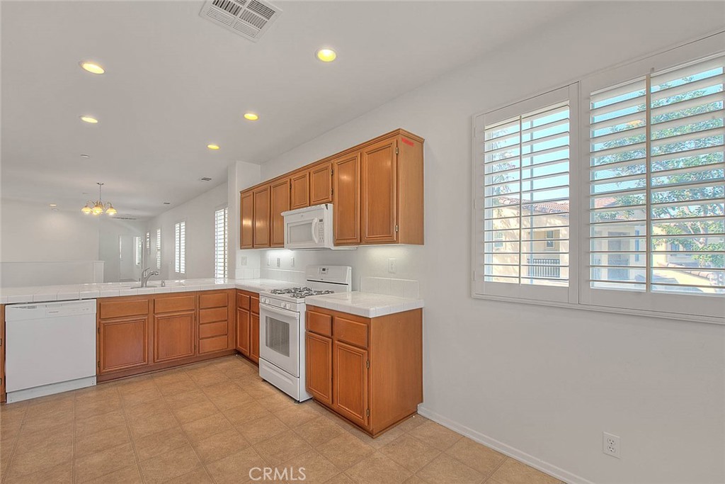 8150 West Preserve Loop Chino, CA 91708 - Photo 26 of 51 a kitchen with a sink stove and cabinets
