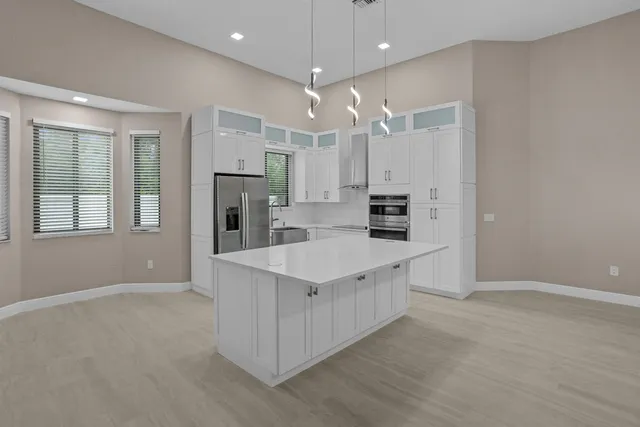 a kitchen with kitchen island stainless steel appliances a sink stove and refrigerator