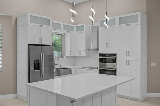 a kitchen with stainless steel appliances a refrigerator sink and cabinets