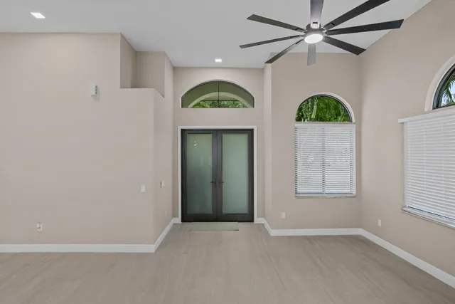 an empty room with windows and fan