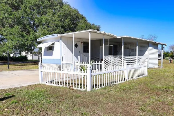 a view of a house with a small yard and fence