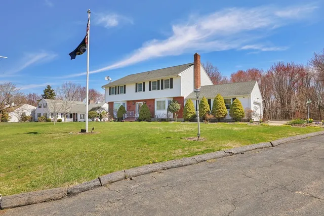 a view of a house with a big yard and a large trees