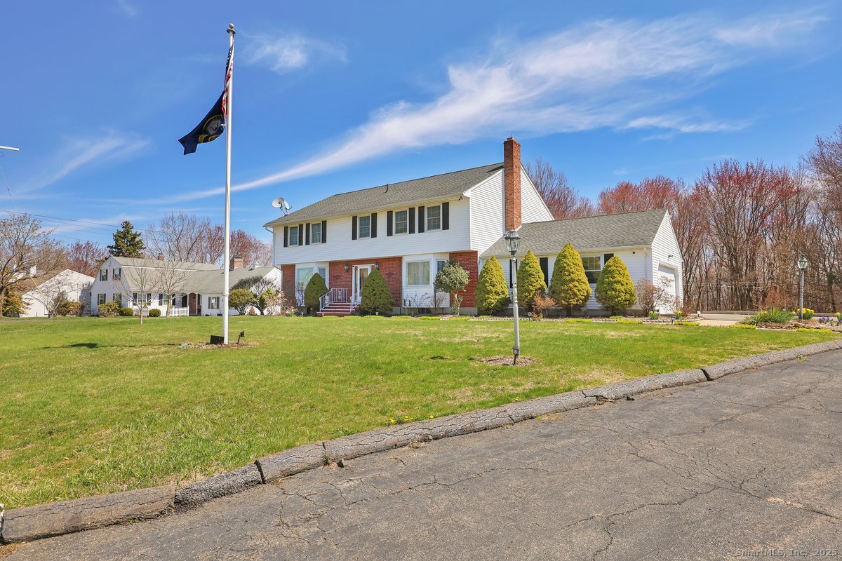 a view of a house with a big yard and a large trees