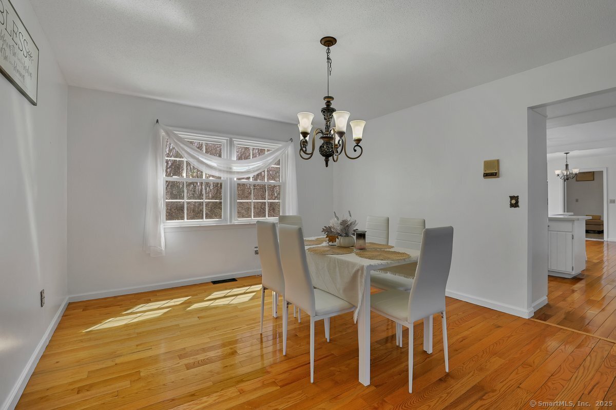 96 Neill Drive Watertown, CT 06795 - Photo 11 of 20 a view of a dining room with furniture a chandelier and wooden floor