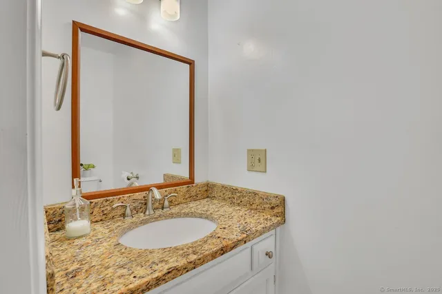 a bathroom with a granite countertop sink and a mirror