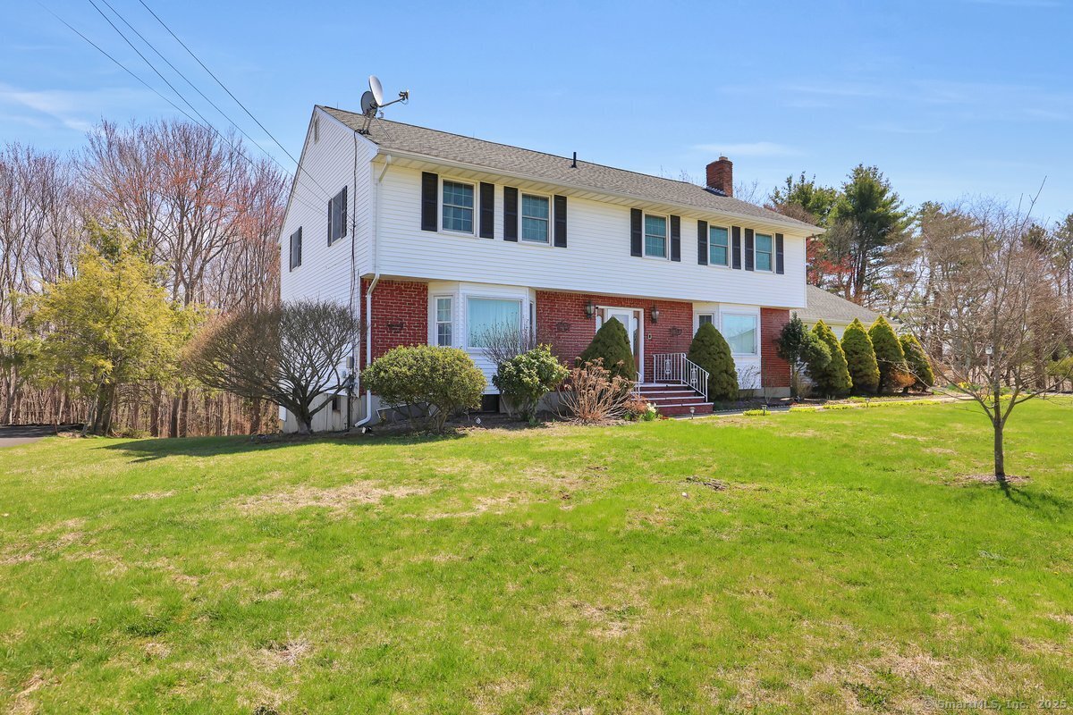 96 Neill Drive Watertown, CT 06795 - Photo 2 of 20 a front view of house with yard and trees in the background