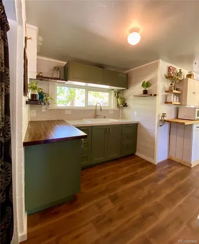 a kitchen with stainless steel appliances granite countertop a sink and cabinets with wooden floor