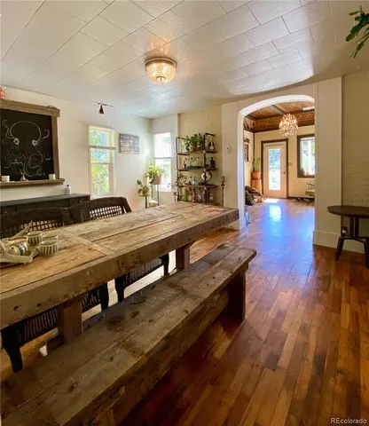 a living room with stainless steel appliances furniture a rug and a flat screen tv