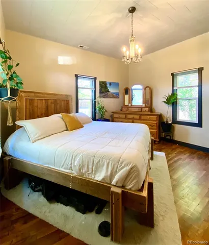 a bed sitting in a spacious bedroom next to a window