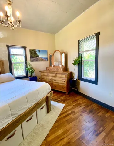 a spacious bedroom with a bed next to a window with a flat screen tv