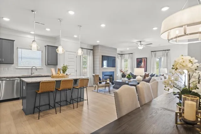 a kitchen with granite countertop a table chairs microwave and cabinets