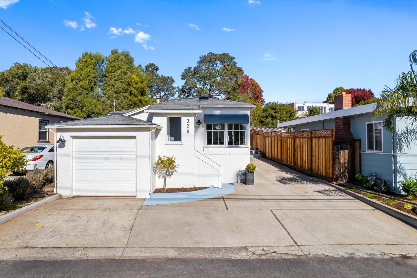 320 Hillcrest Drive Aptos, CA 95003 - Photo 2 of 36 a view of a white house with a small yard and a garage