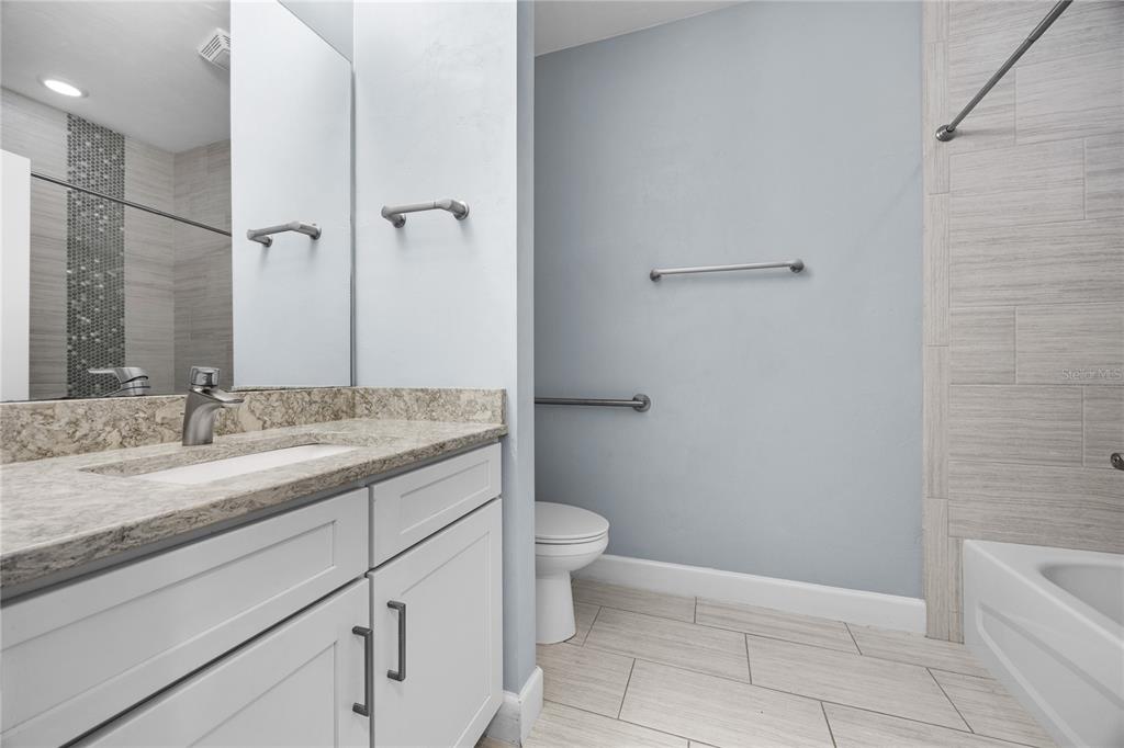 1088 Northwest 126 Way Newberry, FL 32669 - Photo 11 of 29 a bathroom with a granite countertop sink a toilet and a mirror