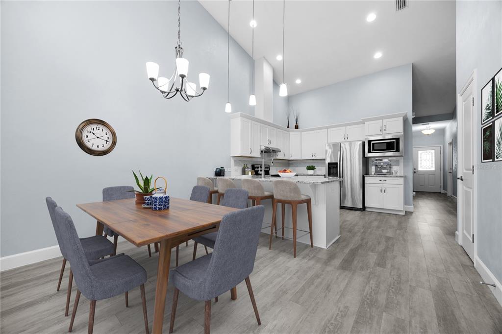 1088 Northwest 126 Way Newberry, FL 32669 - Photo 18 of 29 a view of kitchen with refrigerator a microwave oven a stove and chairs with wooden floor