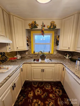 a kitchen with granite countertop a sink stove and cabinets