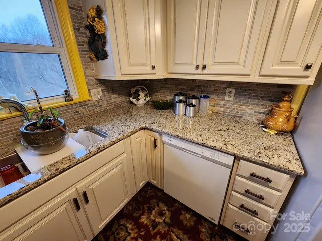 a kitchen with stainless steel appliances granite countertop a sink a stove and a microwave oven