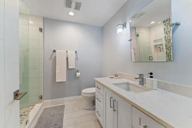 a bedroom with a bed a computer on desk and a dresser