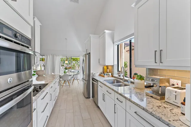 a kitchen with stainless steel appliances granite countertop a sink stove and refrigerator