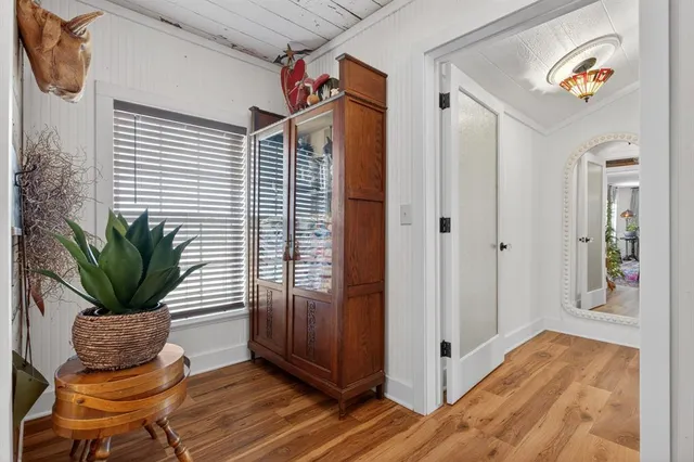 a hallway with wooden floor and glass top table
