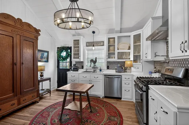 a kitchen with stainless steel appliances a stove a table and chairs