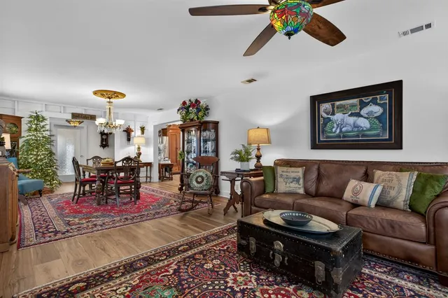 a living room with furniture and a dining table with garden view