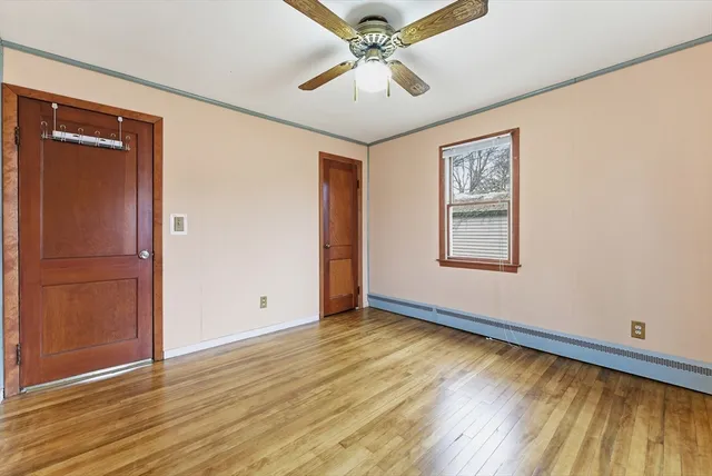 a view of an empty room with window and wooden floor