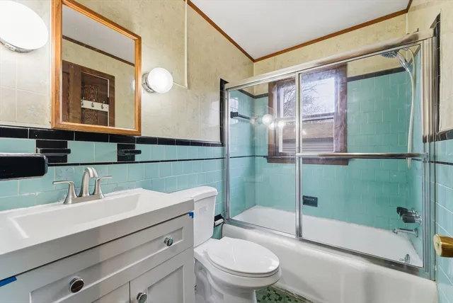 a bathroom with a sink a mirror a toilet and shower