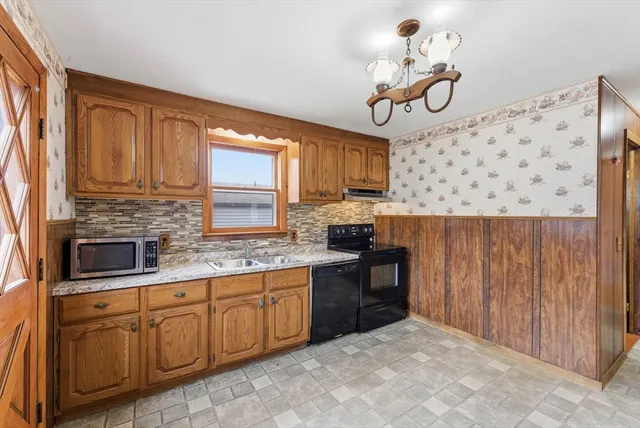 a kitchen with granite countertop a sink stainless steel appliances and cabinets
