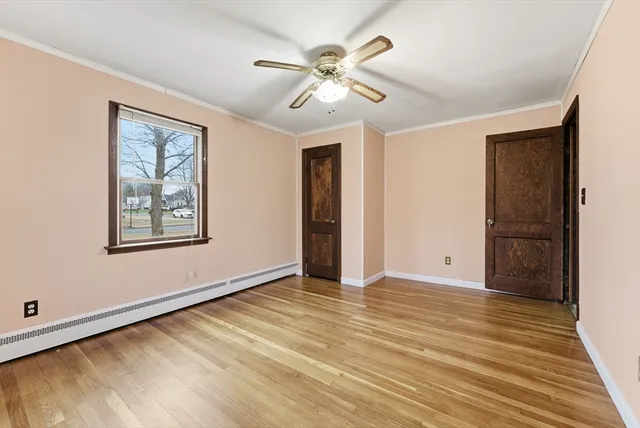 a view of an empty room with window and wooden floor