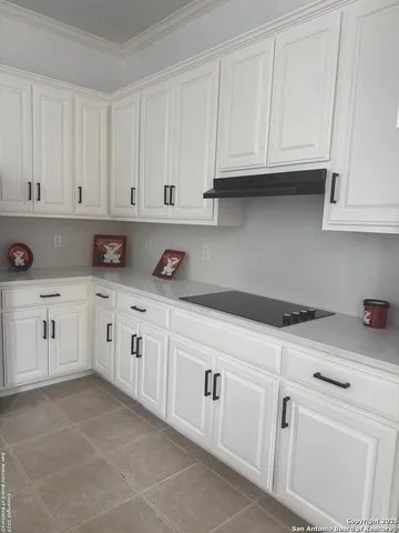 a kitchen with white cabinets and white appliances