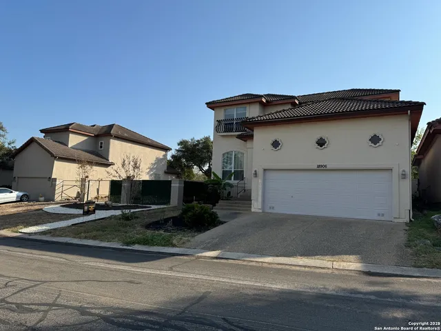 a white house that has tree in front of it