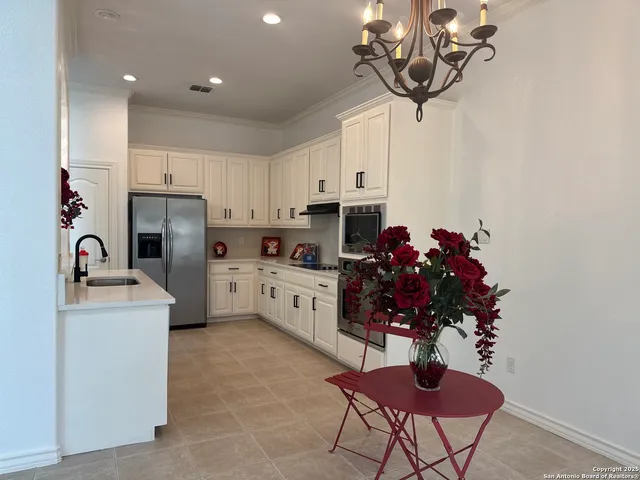 a kitchen with stainless steel appliances granite countertop a sink a stove and a refrigerator