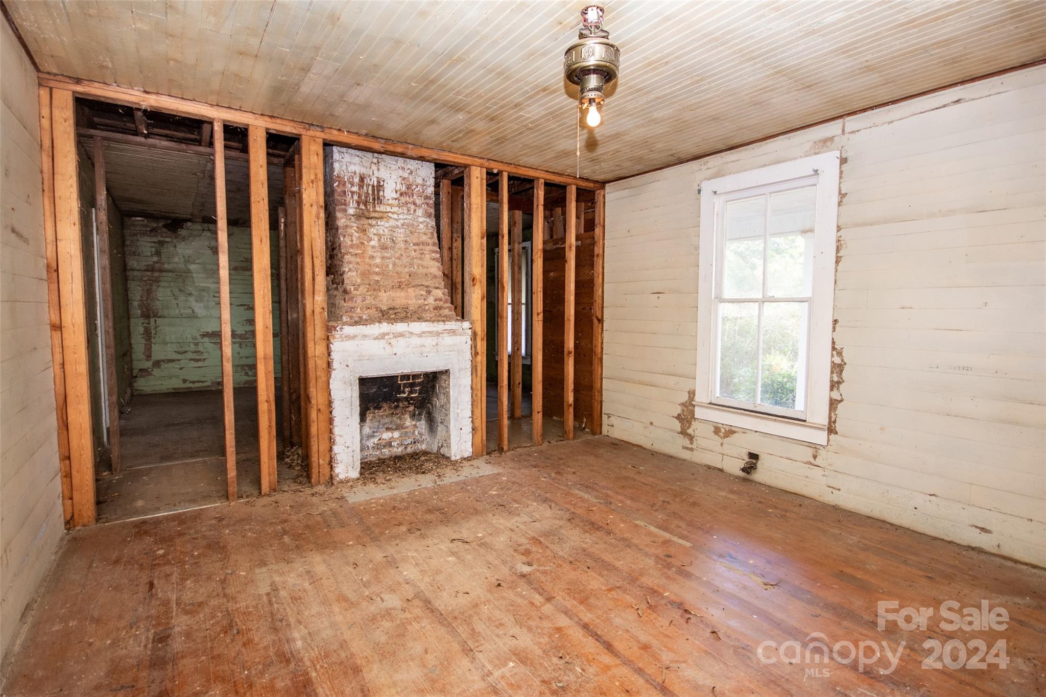 431 Friendship Road Olin, NC 28660 - Photo 21 of 44 a view of an empty room with a fireplace and a window