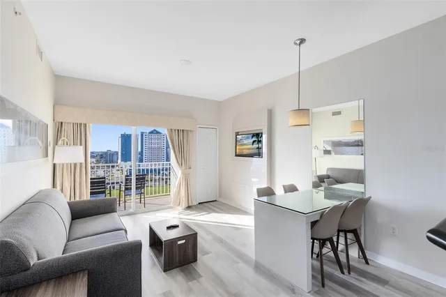 a living room with furniture a large window and a table