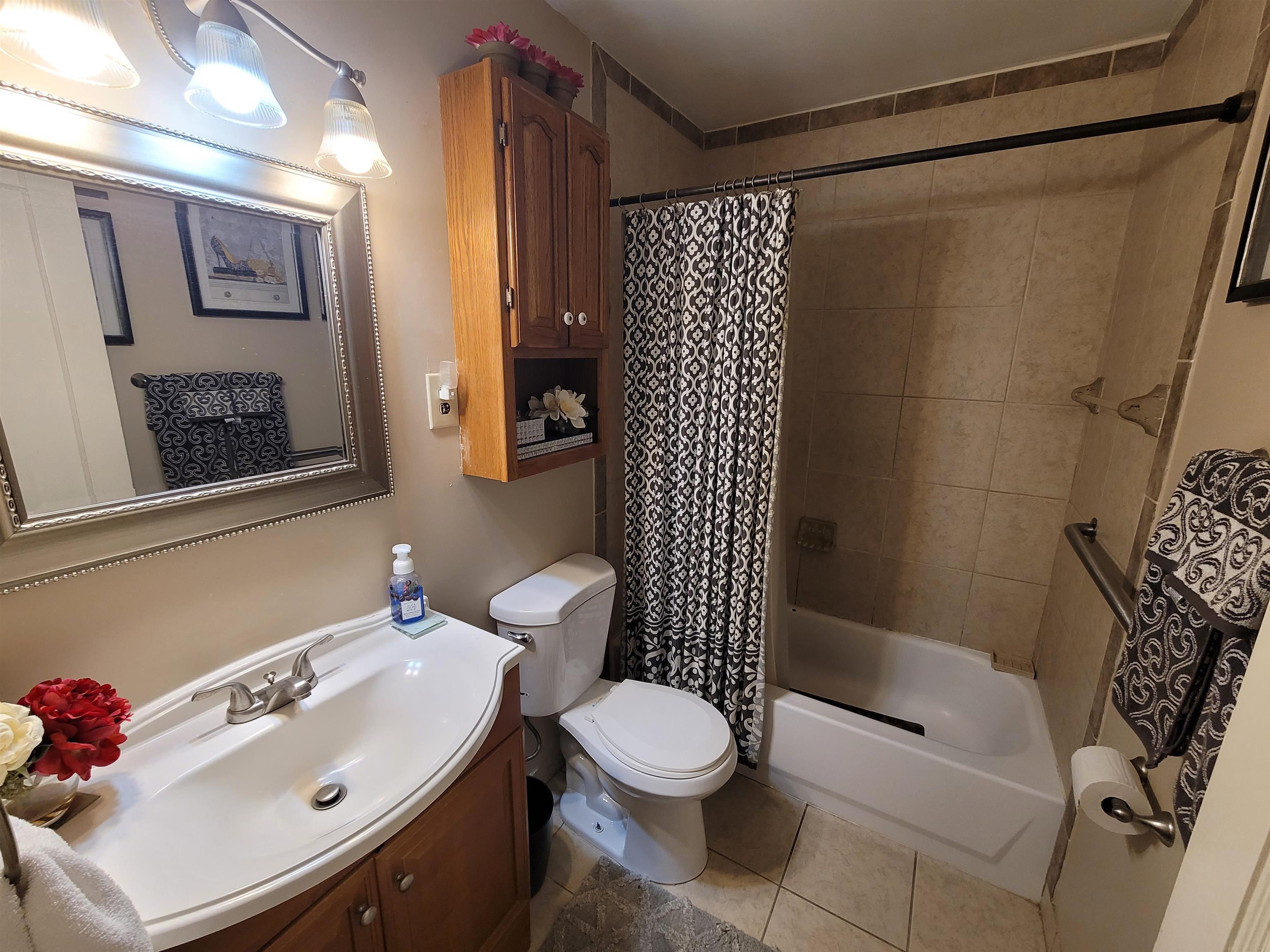 476 Jenson Road Memphis, TN 38109 - Photo 24 of 30 Bathroom featuring a vanity with a white basin sink, polished chrome faucet, and wood-finish cabinetry