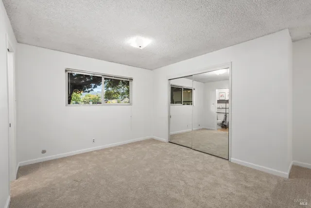 an empty room with windows and closet