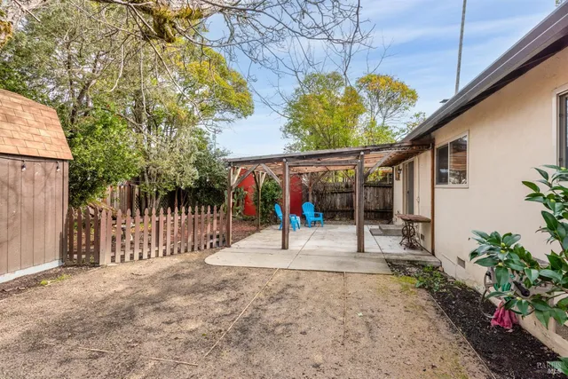 a view of a backyard with a patio and iron fence