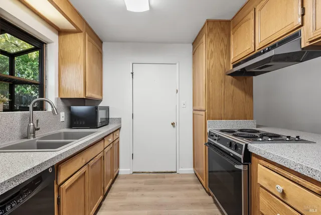 a kitchen with stainless steel appliances granite countertop a sink a stove and a refrigerator