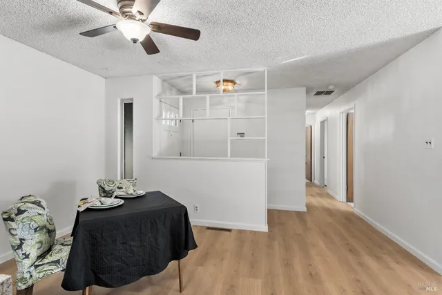 an empty room with wooden floor fireplace and windows