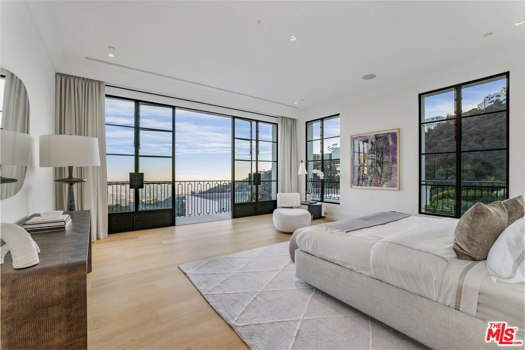 1898 Rising Glen Road Los Angeles, CA 90069 - Photo 23 of 38 a spacious bedroom with a large bed and a large window